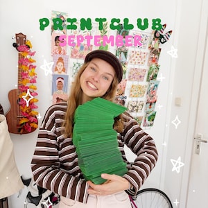 Op de afbeelding: Een persoon draagt een bruin-wit gestreept shirt met lange mouwen en een bruine pet, en houdt een grote stapel felgroene enveloppen vast. De tekst PRINTCLUB SEPTEMBER staat in groene en roze letters boven het hoofd van de persoon.