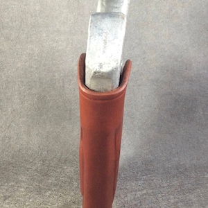 May include: A brown leather holster for a small silver handgun.