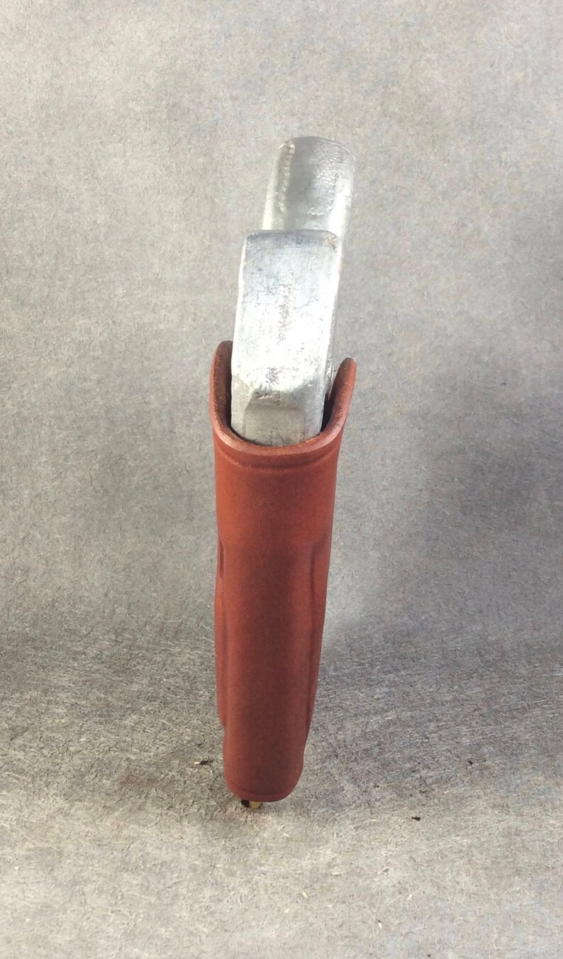 May include: A brown leather holster for a small silver handgun.