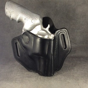 May include: A black leather holster for a silver revolver. The holster has a belt loop and a snap closure.