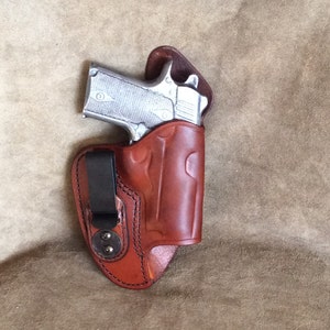 Peut inclure: Un étui en cuir marron avec une pince pour un pistolet. L'étui a un design décoratif et est fait de cuir de haute qualité.