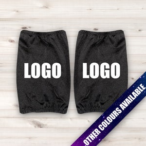 May include: Two black arm warmers with the word "LOGO" printed in white on each. The arm warmers are on a white wood background. Other colors are available.