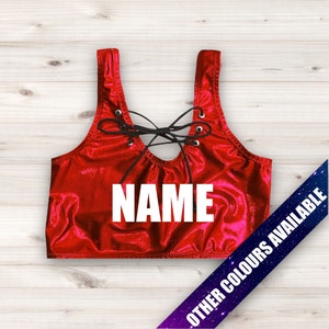 May include: Red lace-up sports bra with the word "NAME" printed in white on the front.  Other colors are available.