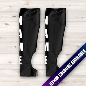 May include: A pair of black arm warmers with the word "NAME" printed vertically in white on each warmer.