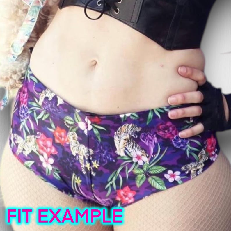 May include: Purple and black shorts with a tropical print featuring tigers, flowers, and leaves. The shorts are shown on a model and the text "FIT EXAMPLE" is visible at the bottom of the image.