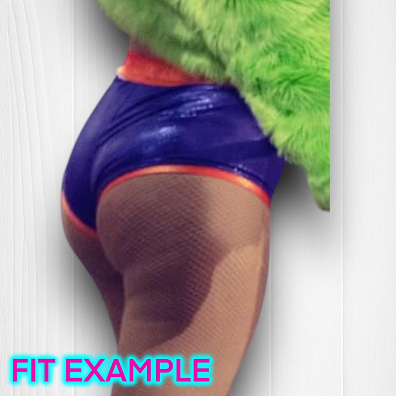 May include: A close-up of a person's backside wearing a blue and orange shiny shorts with a green fuzzy jacket. The person is wearing fishnet stockings.