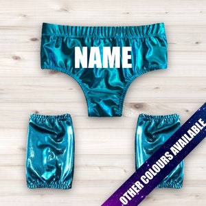 May include: A turquoise metallic wrestling costume with leg warmers. The costume has the word "NAME" printed on the front.