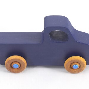 Handmade wooden toy pickup truck handmade and painted navy blue with amber shellac wheels and metallic sapphire blue trim. It's a little blue truck from my Play Pal Collection.