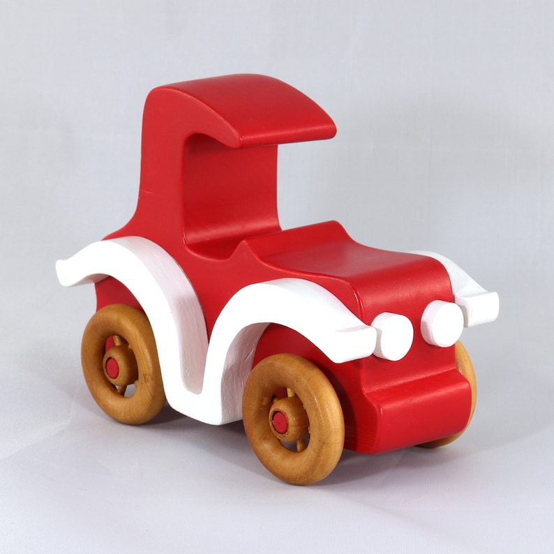 Handmade wooden toy car, vintage style red Model T Coupe by Odin's Toy Factory. Two-tone red and white acrylic paint with spoked wooden wheels finished in amber shellac. Approximate dimensions: 5 inches long, 4 inches high, 2.5 inches wide. Part of Bad Bob’s Custom Motors Collection. Crafted from natural wood using traditional woodworking tools. Handmade in Tallahassee, Florida, USA.