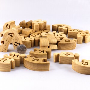 Hand-cut Alphabet Snake Puzzle made from premium hardwood, finished with mineral oil and beeswax for durability. Each of the 26 pieces represents a letter, promoting alphabet learning and essential skills development in kids through play.