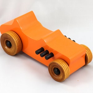 Handmade wooden toy car modeled after a 1927 T-Bucket hot rod. Finished with orange and black acrylic paint and amber shellac.