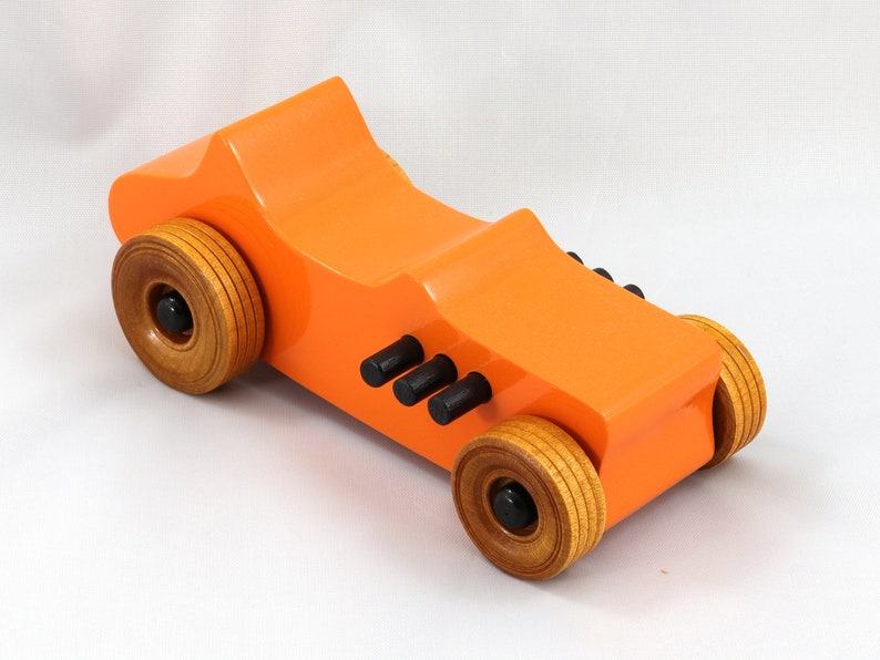 Handmade wooden toy car modeled after a 1927 T-Bucket hot rod. Finished with orange and black acrylic paint and amber shellac.