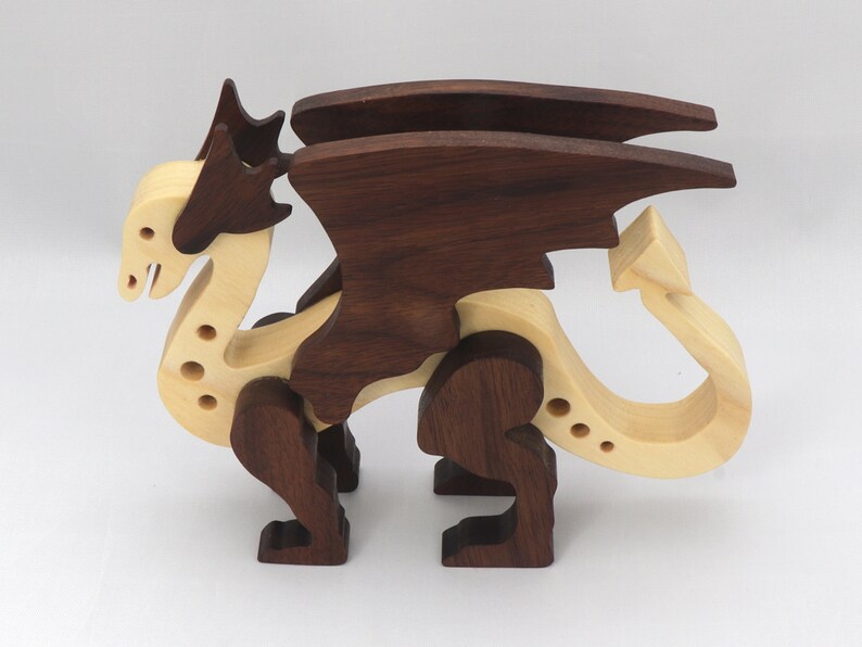 Handmade wooden dragon figurine made from contrasting hardwoods with a light natural wood body and head paired with rich dark reddish-brown wings, legs, and horns.