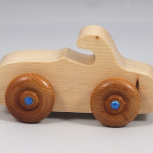 Handmade wooden toy car. The body is finished with clear shellac, and the wheels are finished with amber shellac. The hubs are painted with metallic sapphire blue trim.