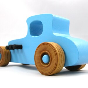 Handmade wooden toy car modeled after a '27 T-Coupe, finished with baby blue and black acrylic paint with nonmarring amber shellac wheels from my hot rod collection.