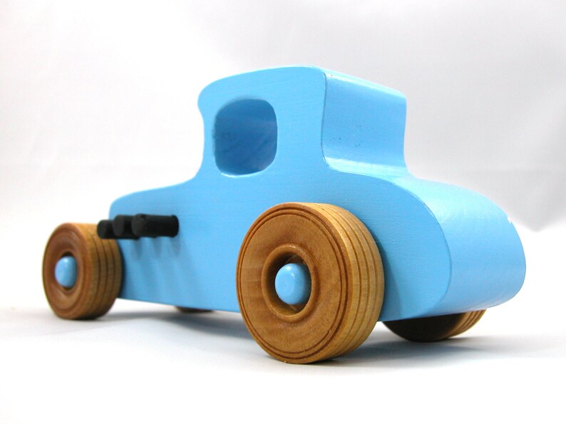 Handmade wooden toy car modeled after a '27 T-Coupe, finished with baby blue and black acrylic paint with nonmarring amber shellac wheels from my hot rod collection.