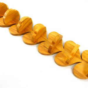 Handmade heart-shaped shelf crafted from reclaimed oak hardwood and finished with polyurethane. Perfect for displaying small items and adding rustic charm to home decor.