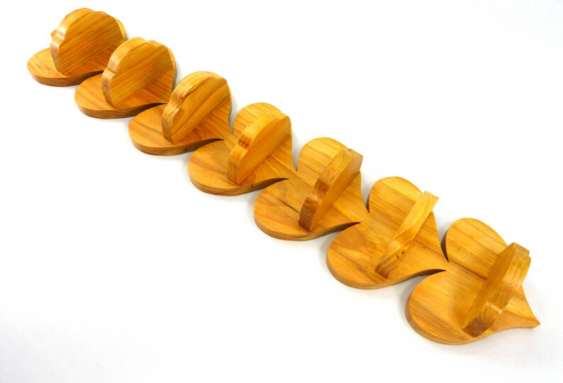 Handmade heart-shaped shelf crafted from reclaimed oak hardwood and finished with polyurethane. Perfect for displaying small items and adding rustic charm to home decor.