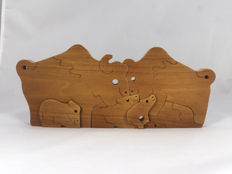 Wooden 6-piece bison family puzzle with two adult bison and four calves. The hardwood pieces interlock into one standing group or separate to stand alone. Handnmade in Tallahassee, Florida, USA by Odin's Toy Factory.
