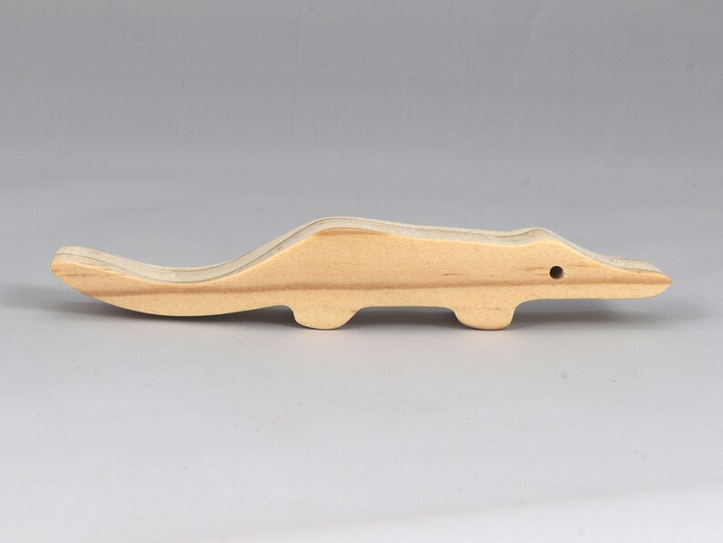 Handmade toy alligator cutout from the Itty Bitty Animal Collection. Crafted with traditional woodworking tools, this unfinished wood alligator is freestanding, smooth-sanded, and ready to paint. Perfect for stacking and imaginative play.
