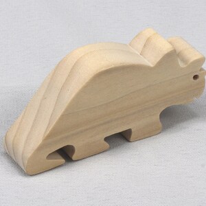This is an unfinished wooden Wooden Toy Dinosaur Triceratops cutout from solid wood using traditional woodworking techniques. Sanded smooth and ready to paint, stain, or customize. Freestanding design for small hands, toddlers, young children, crafters, collectors, and display. I take custom orders for any animal, quantity, and mix — including large ornament orders. Mix and match, request a different size, or send a drawing or pattern. Handmade by Odin's Toy Factory in Tallahassee, Florida, USA.