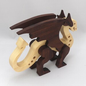 Handmade wooden dragon figurine made from contrasting hardwoods with a light natural wood body and head paired with rich dark reddish-brown wings, legs, and horns.