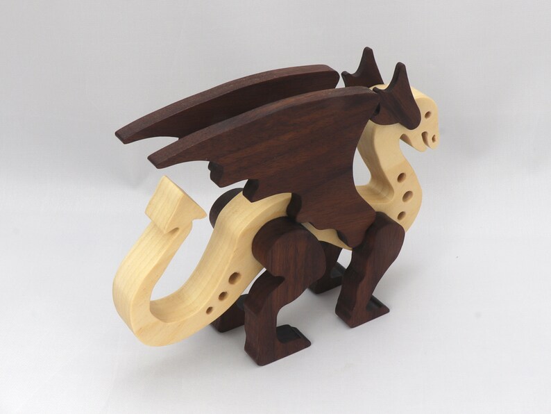 Handmade wooden dragon figurine made from contrasting hardwoods with a light natural wood body and head paired with rich dark reddish-brown wings, legs, and horns.
