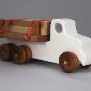 Handmade wooden toy lumber truck from Odin's Toy Factory Easy 5 Truck Fleet Collection. Painted lumber truck with acrylic body, shellac bed, and wheels. Measures approximately 9 inches long, 4 inches high, and 3.5 inches wide. Handmade in Tallahassee, Florida, USA. Custom colors available.