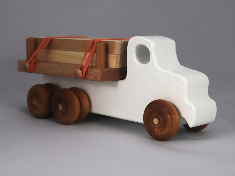 Handmade wooden toy lumber truck from Odin's Toy Factory Easy 5 Truck Fleet Collection. Painted lumber truck with acrylic body, shellac bed, and wheels. Measures approximately 9 inches long, 4 inches high, and 3.5 inches wide. Handmade in Tallahassee, Florida, USA. Custom colors available.