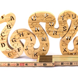 Hand-cut Alphabet Snake Puzzle made from premium hardwood, finished with mineral oil and beeswax for durability. Each of the 26 pieces represents a letter, promoting alphabet learning and essential skills development in kids through play.