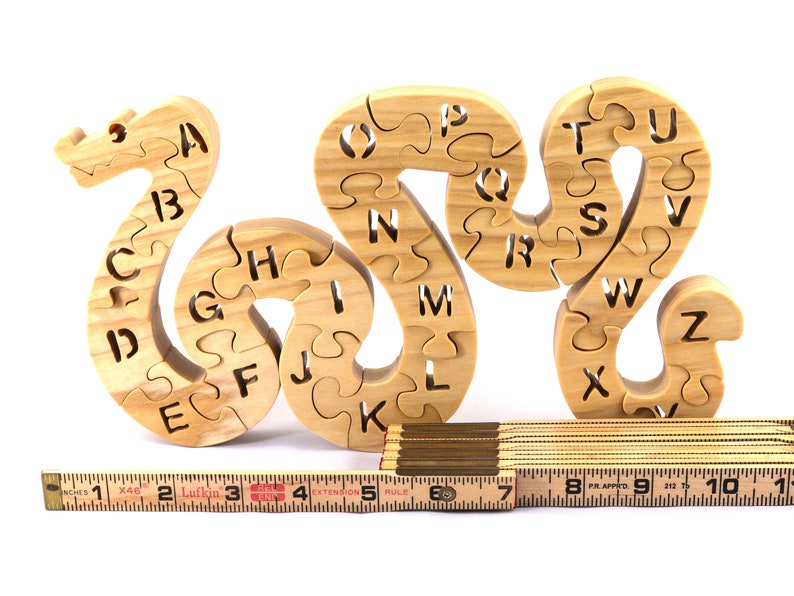 Hand-cut Alphabet Snake Puzzle made from premium hardwood, finished with mineral oil and beeswax for durability. Each of the 26 pieces represents a letter, promoting alphabet learning and essential skills development in kids through play.