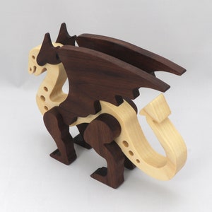 Handmade wooden dragon figurine made from contrasting hardwoods with a light natural wood body and head paired with rich dark reddish-brown wings, legs, and horns.