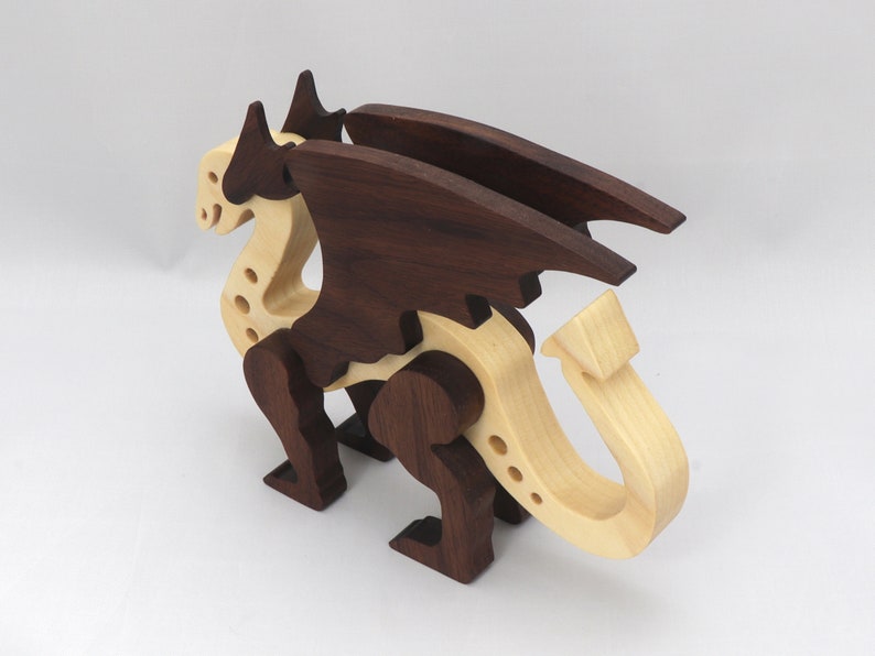 Handmade wooden dragon figurine made from contrasting hardwoods with a light natural wood body and head paired with rich dark reddish-brown wings, legs, and horns.