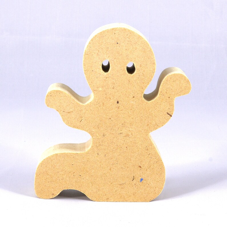 A handmade, unpainted wooden ghost cutout stands upright on a white background. The light-colored solid wood figure has a rounded head with two circular eye cutouts, raised wavy arms, and a curved wavy base, ready for painting or crafting.