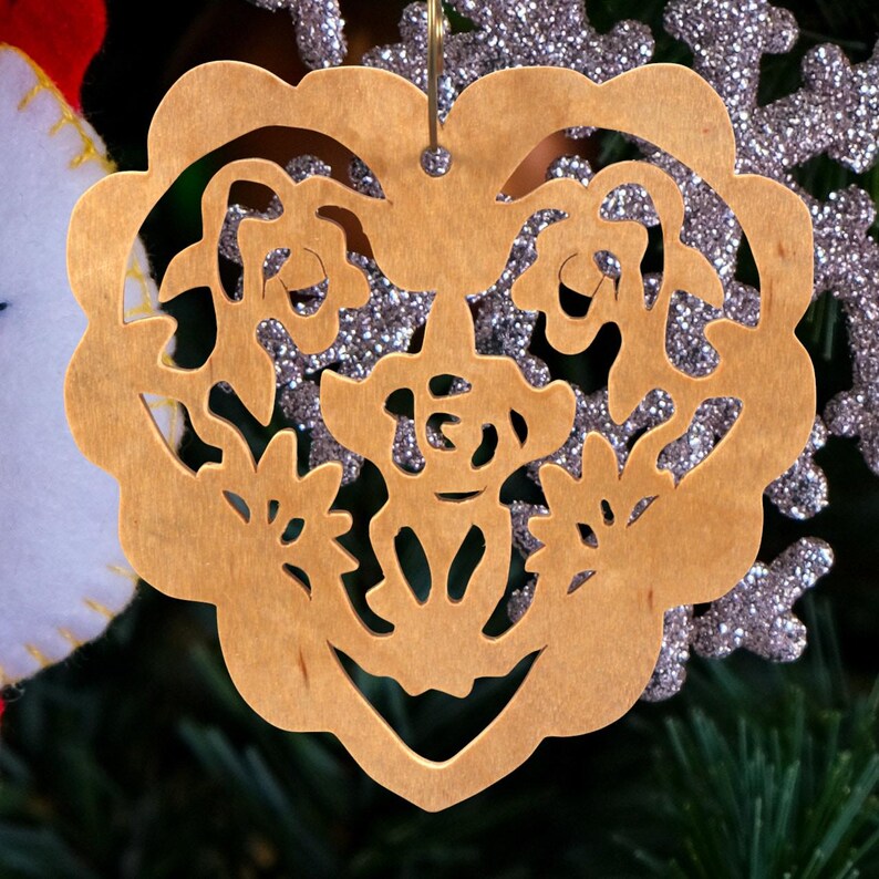 A handmade wooden Victorian-style fretwork floral heart Christmas tree ornament, featuring intricate cutout floral patterns in a heart shape, with a warm natural wood finish.