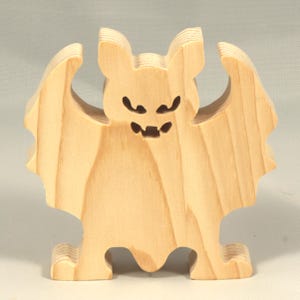 Handmade unpainted wooden Halloween bat cutout, freestanding light-colored solid wood figure with spooky carved face and outstretched wings, ready to paint, from my Snazzy Spooks collection.