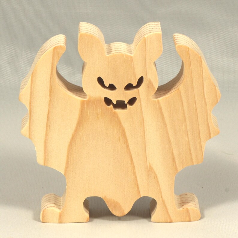 Handmade unpainted wooden Halloween bat cutout, freestanding light-colored solid wood figure with spooky carved face and outstretched wings, ready to paint, from my Snazzy Spooks collection.