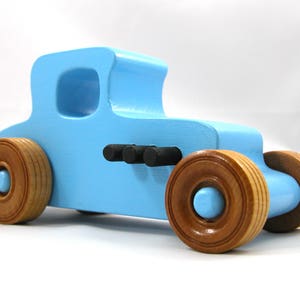 Handmade wooden toy car modeled after a '27 T-Coupe, finished with baby blue and black acrylic paint with nonmarring amber shellac wheels from my hot rod collection.
