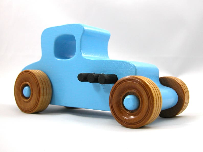 Handmade wooden toy car modeled after a '27 T-Coupe, finished with baby blue and black acrylic paint with nonmarring amber shellac wheels from my hot rod collection.