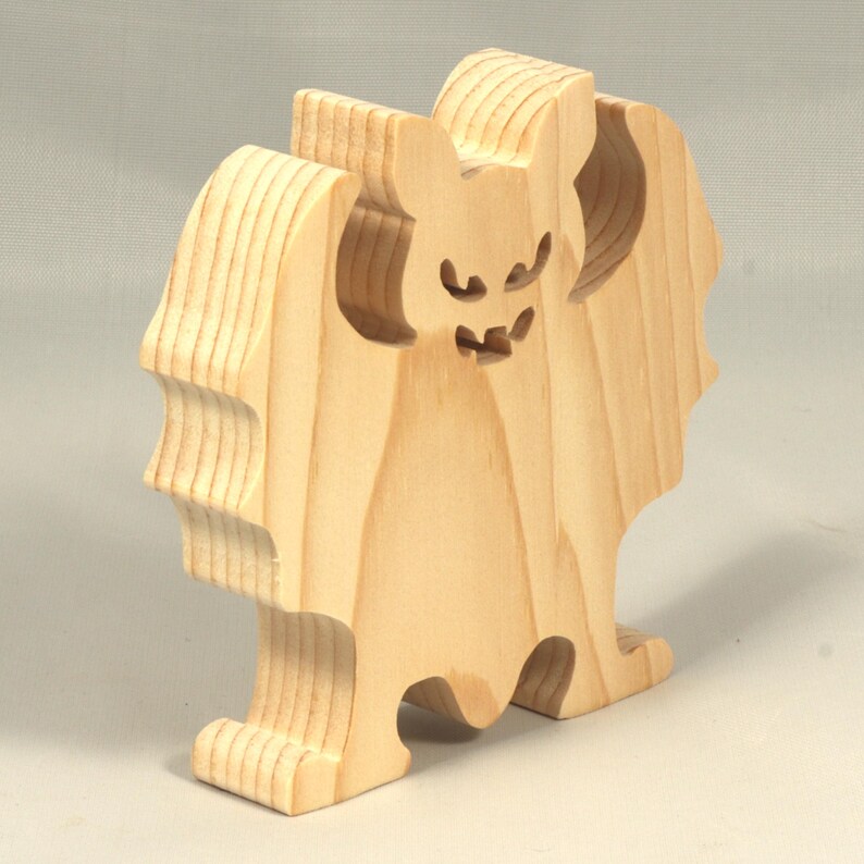 Handmade unpainted wooden Halloween bat cutout, freestanding light-colored solid wood figure with spooky carved face and outstretched wings, ready to paint, from my Snazzy Spooks collection.