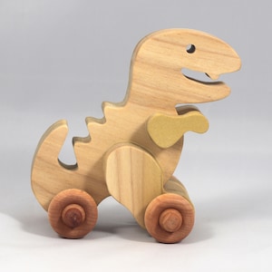Handmade wooden push toy Tyrannosaurus Rex dinosaur made from select grade hardwoods and finished with a non-toxic coating.