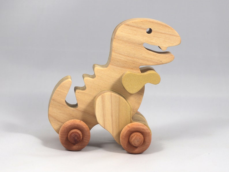 Handmade wooden push toy Tyrannosaurus Rex dinosaur made from select grade hardwoods and finished with a non-toxic coating.