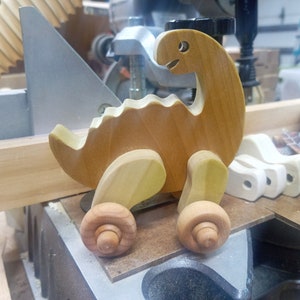 Handmade wooden push toy dinosaur made from select grade hardwoods and finished with a non-toxic coating.
