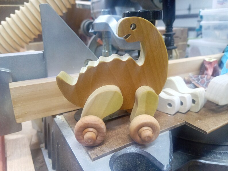 Handmade wooden push toy dinosaur made from select grade hardwoods and finished with a non-toxic coating.