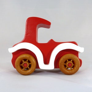 Handmade wooden toy car, vintage style red Model T Coupe by Odin's Toy Factory. Two-tone red and white acrylic paint with spoked wooden wheels finished in amber shellac. Approximate dimensions: 5 inches long, 4 inches high, 2.5 inches wide. Part of Bad Bob’s Custom Motors Collection. Crafted from natural wood using traditional woodworking tools. Handmade in Tallahassee, Florida, USA.