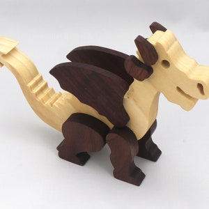 Wood Dragon Fantasy Animal Figurine is Handmade and finished with a renewable blend of mineral oil and waxes Applied hot for durabiliity and to enhance the beauty of the wood. There are ten dragons in this collection. A  link is in the description.