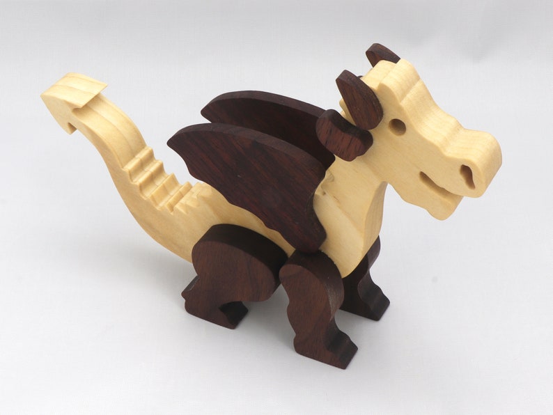 Wood Dragon Fantasy Animal Figurine is Handmade and finished with a renewable blend of mineral oil and waxes Applied hot for durabiliity and to enhance the beauty of the wood. There are ten dragons in this collection. A  link is in the description.