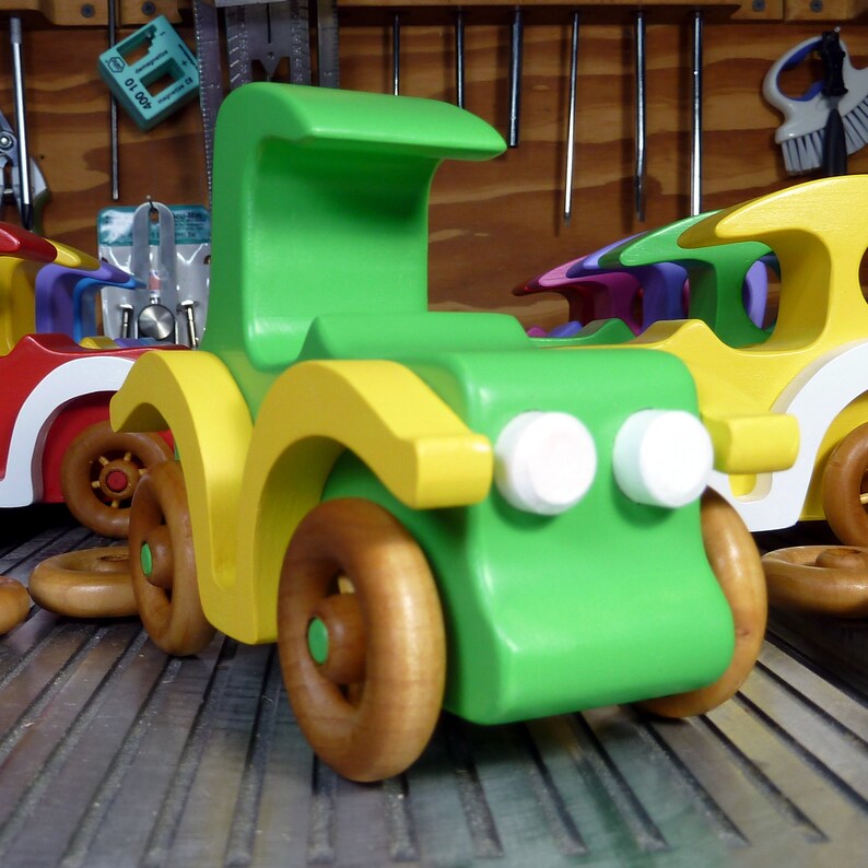 Handmade wooden toy car, vintage-style Model T sedan, painted bright green and yellow with spoked wheels, finished in amber shellac.  Handcrafted in Tallahassee, Florida, USA by Odin's Toy Factory.