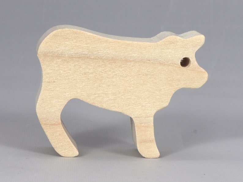 Handmade unfinished wooden toy baby calf cutout, unpainted and ready to paint, freestanding farm animal figure from Odin's Toy Factory’s  Itty Bitty Animal Collection. Handcrafted in Tallahassee, Florida, USA, using reclaimed natural wood offcuts. Perfect for imaginative play, stacking, collectors, and crafting.