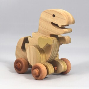 Handmade wooden push toy Tyrannosaurus Rex dinosaur made from select grade hardwoods and finished with a non-toxic coating.